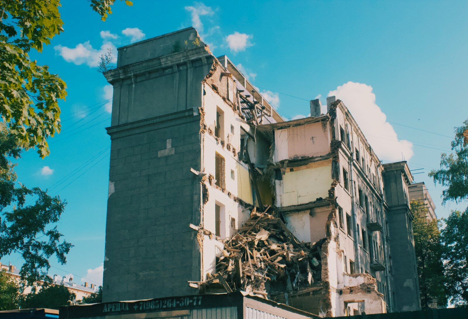 Demolished building with debris against blue sky
